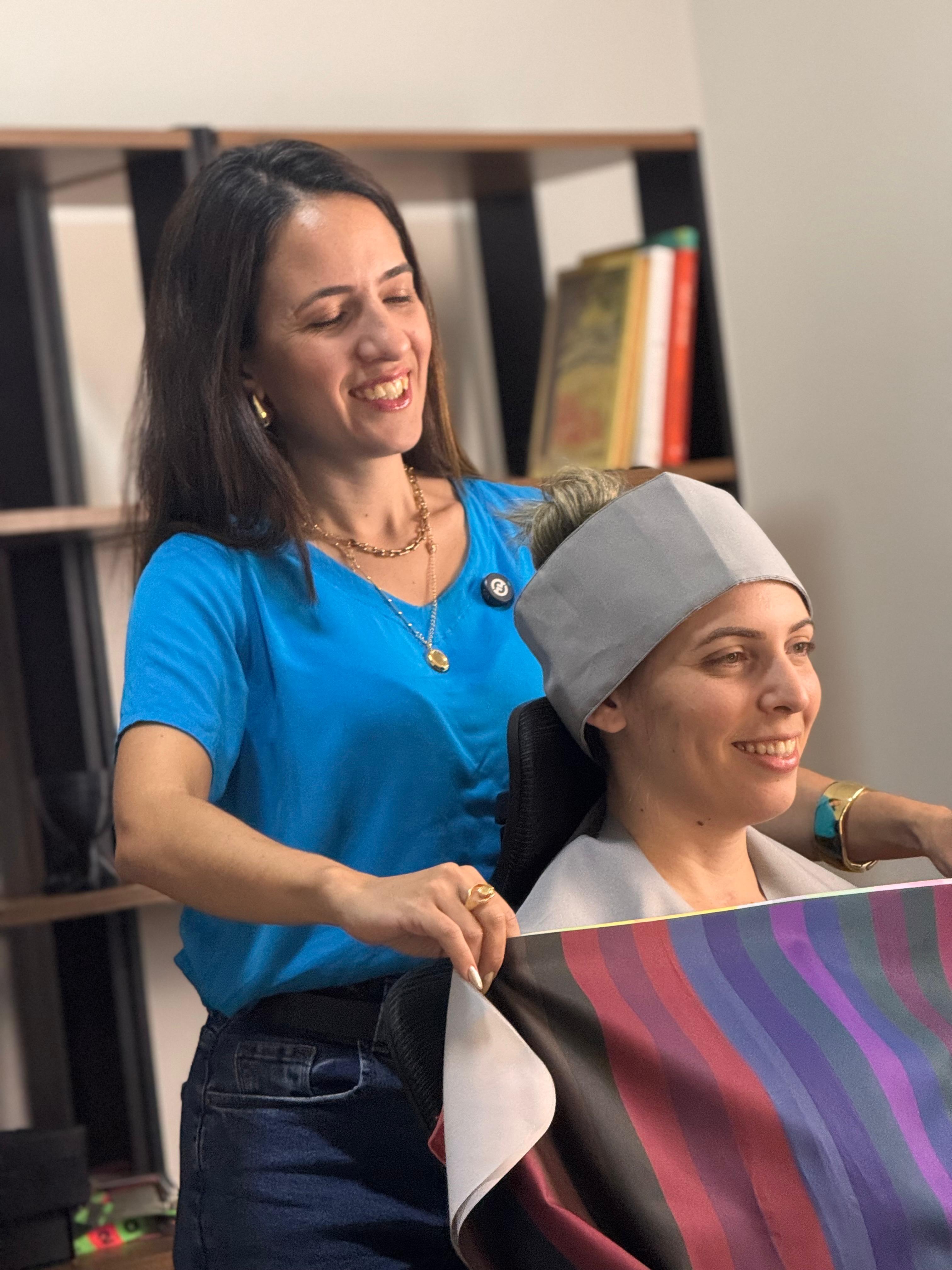 Vanessa Bento aplicando tecidos coloridos no rosto de uma cliente